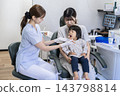 A 2-year-old girl and her mother receiving toothbrushing instruction at a dental clinic. 143798814