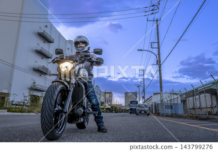 一名男騎士在日落時分騎行穿過台場的倉庫區。 143799276