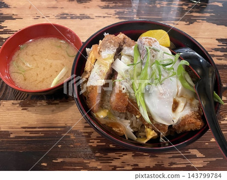 Japanese katsudon pork cutlet rice bowl served with miso soup on a wooden table Japanese katsudon pork cutlet rice bowl served with miso soup on a wooden table 143799784