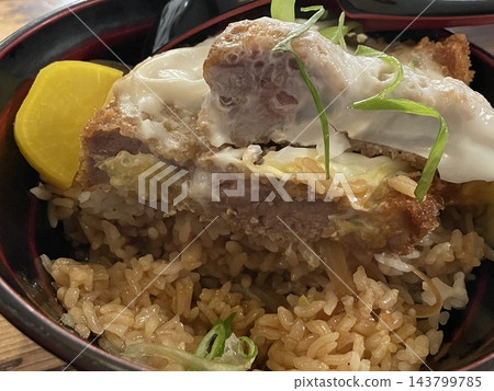 Close up view of japanese katsudon pork cutlet showing layers of meat egg and rice Close up view of japanese katsudon pork cutlet showing layers of meat egg and rice 143799785