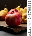 Ripe red pomegranates and yellow pears on a wooden board 143799811