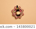 Cosmetic dropper bottle with a blank label on a woven stand, top view 143800021
