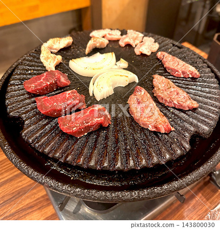 在圓形烤盤上烤製的肉和洋蔥 143800030