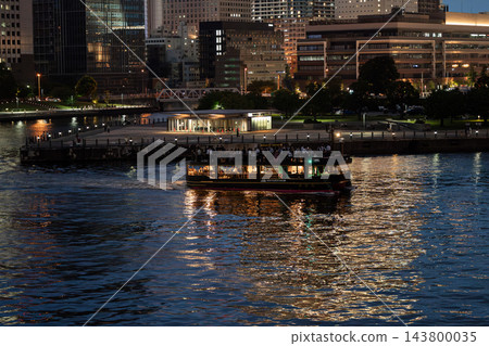 夜幕降臨,觀光船駛過港口,以橫濱港未來區的摩天大樓為背景。 夜幕降臨,觀光船駛過港口,以橫濱港未來區的摩天大樓為背景。 143800035
