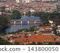 Aerial high angle view of river water dam and watergate surrounded by dense residential houses and cityscape in Surabaya 143800050