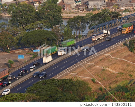 High angle view of busy multi-lane toll road and bridge with trucks and cars driving over Kali Surabaya river High angle view of busy multi-lane toll road and bridge with trucks and cars driving over Kali Surabaya river 143800111