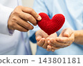 Doctor give red heart to Asian elderly woman patient in hospital. 143801181