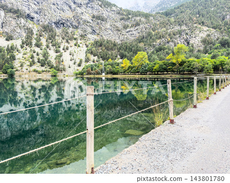 Lakeside gravel path with rope fence and mountain reflection, Panticosa Lakeside gravel path with rope fence and mountain reflection, Panticosa 143801780