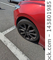 A red car parked inside the white line. 143801985