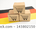 Germany flag with Shopping cart box, import export, finance commerce. 143802150