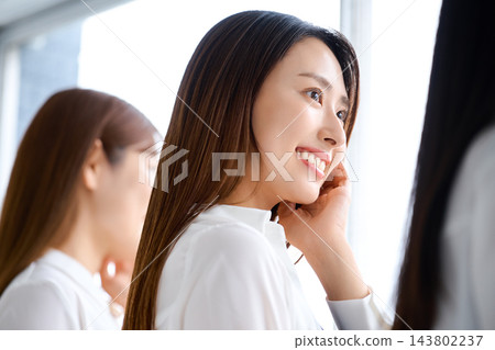 窗邊,一位女士手托腮,微笑。 窗邊,一位女士手托腮,微笑。 143802237