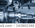 High-precision metal parts manufacturing on a multi-tasking CNC lathe machine in a blue tone scene 143802348