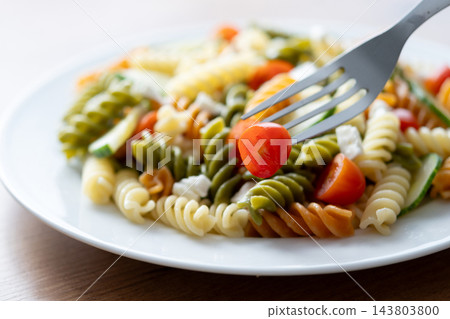 Colorful fusilli pasta salad with fresh vegetables and feta cheese Colorful fusilli pasta salad with fresh vegetables and feta cheese 143803800
