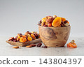 Assorted nuts and dried fruits in wooden dish. 143804397