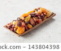 Assorted nuts and dried fruits in wooden dish. 143804398