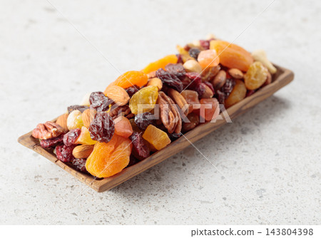 Assorted nuts and dried fruits in wooden dish. Assorted nuts and dried fruits in wooden dish. 143804398