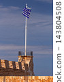 Greek Flag and Historic Stone Arch at Venetian Harbor in Chania, Crete 143804508