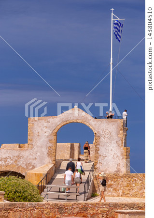 Greek Flag and Historic Stone Arch at Venetian Harbor in Chania, Crete Greek Flag and Historic Stone Arch at Venetian Harbor in Chania, Crete 143804510