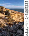Scenic sunset view of sandstone cliffs and canyon leading to Arenosillo beach in Mazagon, Huelva, Spain. Great for travel guides, Andalusian tourism, and nature blogs. 143805325