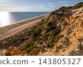 Scenic sunset view of sandstone cliffs and canyon leading to Arenosillo beach in Mazagon, Huelva, Spain. Great for travel guides, Andalusian tourism, and nature blogs. 143805327