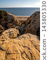Scenic sunset view of sandstone cliffs and canyon leading to Arenosillo beach in Mazagon, Huelva, Spain. Great for travel guides, Andalusian tourism, and nature blogs. 143805330
