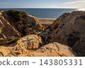 Scenic sunset view of sandstone cliffs and canyon leading to Arenosillo beach in Mazagon, Huelva, Spain. Great for travel guides, Andalusian tourism, and nature blogs. 143805331