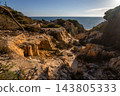 Scenic sunset view of sandstone cliffs and canyon leading to Arenosillo beach in Mazagon, Huelva, Spain. Great for travel guides, Andalusian tourism, and nature blogs. 143805333
