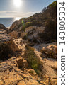 Scenic sunset view of sandstone cliffs and canyon leading to Arenosillo beach in Mazagon, Huelva, Spain. Great for travel guides, Andalusian tourism, and nature blogs. 143805334