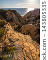 Scenic sunset view of sandstone cliffs and canyon leading to Arenosillo beach in Mazagon, Huelva, Spain. Great for travel guides, Andalusian tourism, and nature blogs. 143805335