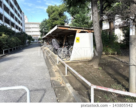 樹木蔥鬱，毗鄰大型公寓大樓，設有有頂棚的室外自行車停車區。 143805542