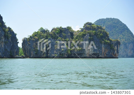 泰國攀牙灣碧綠的海水中漂浮著鬱鬱蔥蔥的綠色岩層。 泰國攀牙灣碧綠的海水中漂浮著鬱鬱蔥蔥的綠色岩層。 143807301