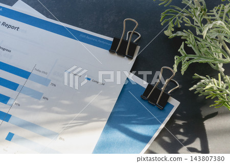 用於將商務文件固定在一起的雙夾子,以及帶有深灰色背景的留白模板,方便放置文字。 用於將商務文件固定在一起的雙夾子,以及帶有深灰色背景的留白模板,方便放置文字。 143807380