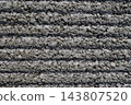 A gray, textured concrete wall. A rough background texture with a series of horizontal stripes. 143807520
