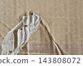 A background texture of brown cardboard with a torn cross-section visible. 143808072
