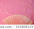 A celebratory image featuring a pink fan and pearls. 143808129
