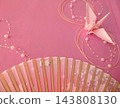 Folding fan and origami crane against a pink background 143808130