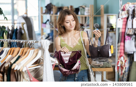 Glad young girl choosing bra in clothing store Glad young girl choosing bra in clothing store 143809561