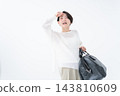 A woman carrying a heavy bag 143810609