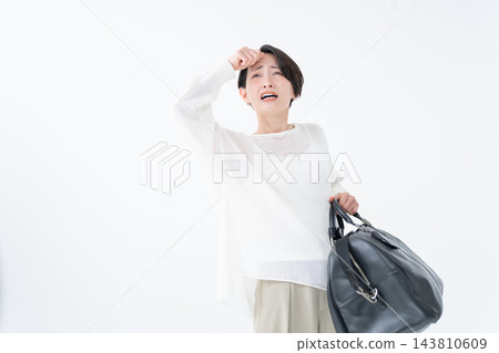 一名女子提著一個沉重的包包 143810609