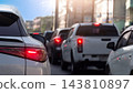 Rear view of cars stuck in slow moving traffic on an urban street during daytime. Highlighting glowing red tail lights and brake lights. Traffic jam in Thailand in business time with town background. 143810897