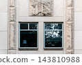 Two Windows in a Pale Stone Wall with Rough and Smooth Panels 143810988