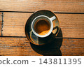 Close-up top view of a perfect espresso shot with golden crema in a ceramic cup on a wooden table 143811395