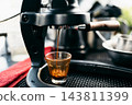 Manual lever espresso machine extracting a fresh shot of coffee. 143811399