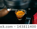 Macro shot of perfect espresso extraction with rich crema pouring into a glass. 143811400