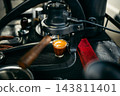 Barista brewing specialty coffee using a manual lever espresso machine at a slow bar. 143811401