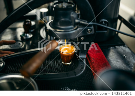 Barista brewing specialty coffee using a manual lever espresso machine at a slow bar. Barista brewing specialty coffee using a manual lever espresso machine at a slow bar. 143811401