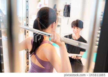 一位女士正在接受私人訓練指導。 一位女士正在接受私人訓練指導。 143811865