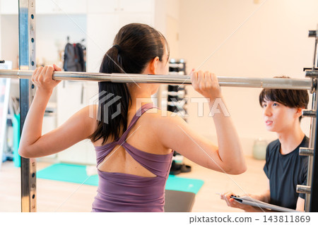 一位女士正在接受私人訓練指導。 一位女士正在接受私人訓練指導。 143811869
