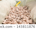 A narrow trench is filled with gravel stones to ensure proper drainage at the construction site. Various construction materials and tools are visible around the area. 143811876
