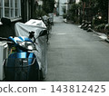 A motorcycle parked in an alleyway 143812425